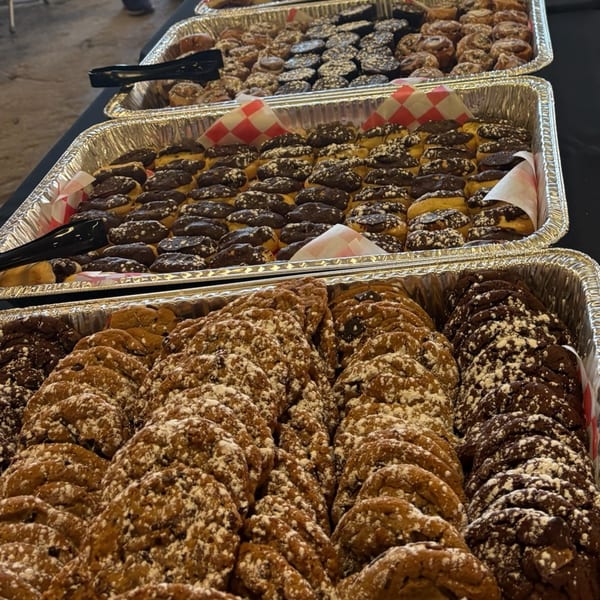 Trays of chocolate-covered eclairs, cinnamon rolls, and powdered sugar cookies from Lena's Kitchen.
