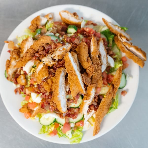 Lena's Kitchen crispy chicken salad with bacon, tomatoes, cucumbers, and hard-boiled egg.